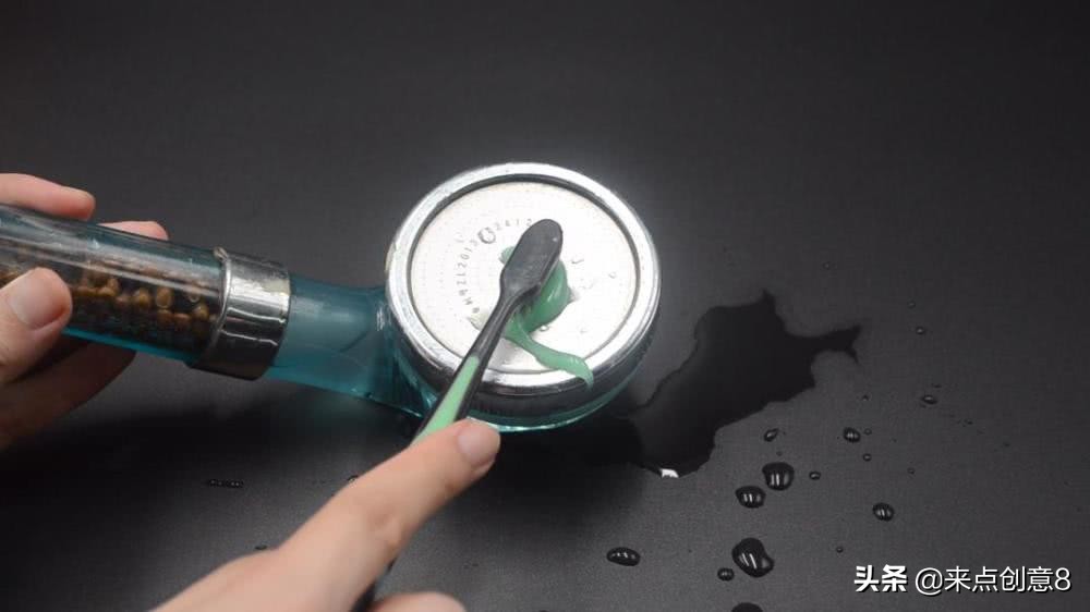 把牙膏涂抹在淋浴喷头上,把牙膏挤到喷水壶里