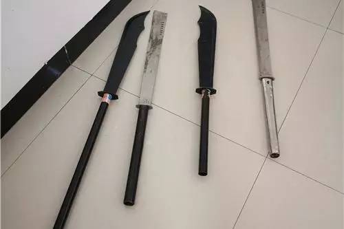 一群精神小伙打架路人拿关公刀,多人持棍棒打砸电动车