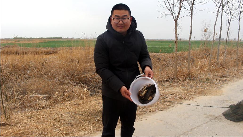 农村小伙在河里抓到一只小鱼,农村小伙河中发现废弃地笼