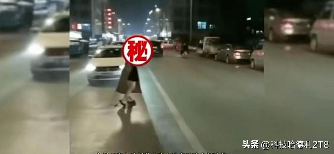 一对男女在马路中央打羽毛球,夜晚两人在马路上打羽毛球